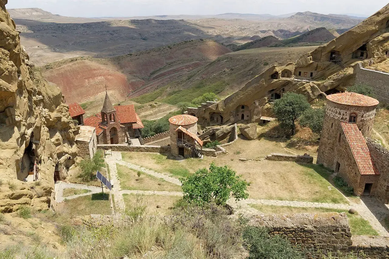 Cave monastery buildings set into ochre cliffs at David Gareji